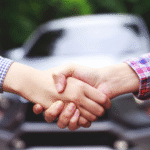 Two people shaking hands over a car rental agreement in Morocco.