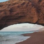 Beach with golden dunes in Morocco, perfect road trip stop with a rental car.